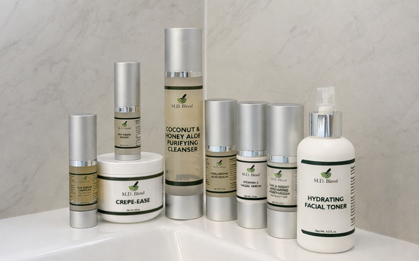 Collection of skincare products on a white surface with a tiled wall background