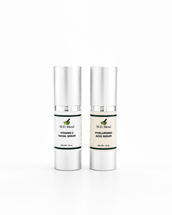 Two M.D. Blend skincare serum bottles featuring Vitamin C Facial Serum and Hyaluronic Acid Serum displayed side by side on a clean white studio background with soft natural shadows.